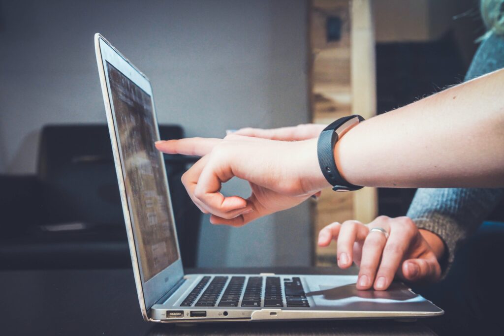 people pointing at the six types of websites on a laptop